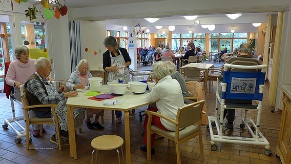 Gemeinschaftsraum mit vielen Menschen in einem Pflegeheim © NDR Info Foto: Bettina Less