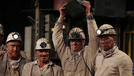 Bergleute stehen nebeneinander mit dem letzten Stück Steinkohle in der Hand. © dpa-Bildfunk Foto: Oliver Berg