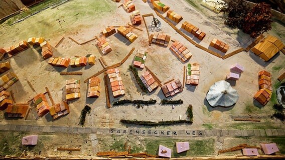 Auf einem Tisch steht das Modell eines Dorfes aus Holz, Stein und Pappe, das eine Gruppe im Wendland in echt bauen möchte. © kina.becker@pictonet Foto: Kina Becker