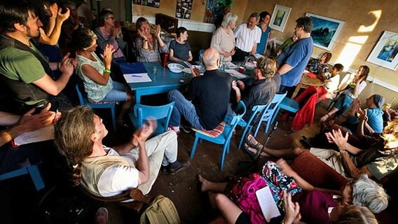 Teilnehmer an einer Versammlung von Dorfgründern im niedersächsischen Wendland sitzen um einen großen runden Tisch zusammen. © kina.becker@pictonet Foto: Kina Becker