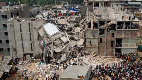 Rettungskräfte stehen im April 2013 auf den Resten einer zusammengestürzten Fabrik in Dhaka in Bangladesch © dpa bildfunk Foto: Abir Abdullah