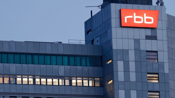 Das beleuchtete Logo des Senders Rundfunk Berlin-Brandenburg (rbb) an der Fassade des Sender-Sitzes in Berlin. © dpa Foto: Carsten Koall