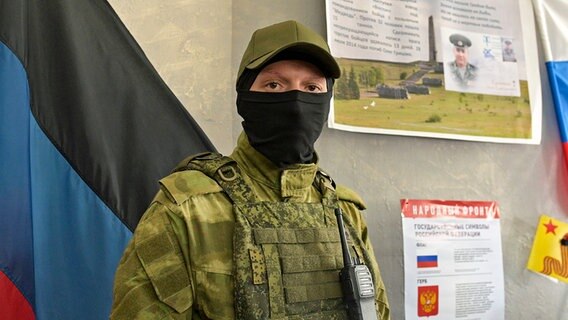 Ein Soldat der Volksrepublik Donezk steht vor einem Wahllokal in Donezk, der von russisch unterstützten Separatisten kontrollierten Volksrepublik Donezk in der Ostukraine. © Uncredited/AP/dpa 