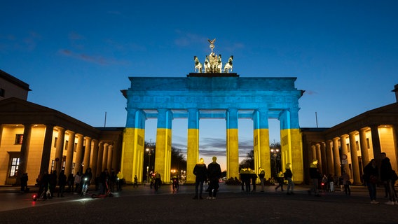 Das Brandenburger Tor in Berlin wird in den Farben der ukrainischen Flagge angestrahlt. © dpa-Bildfunk 