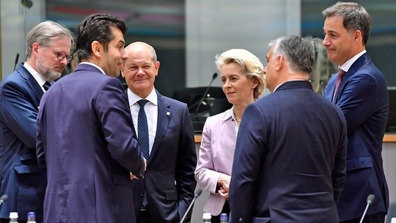 Mehrere Teilnehmende eines EU-Gipfels in Brüssel stehen zusammen, unter anderem Bundeskanzler Olaf Scholz und EU-Kommissionspräsidentin Ursula von der Leyen. © dpa bildfunk/AP Foto: Geert Vanden Wijngaert