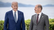 Der US-Präsident Joe Biden und der deutsche Bundeskanzler Olaf Scholz stehen im Freien nebeneinander. © dpa Foto: Michael Kappeler