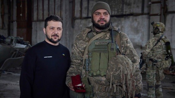 Auf diesem vom Pressebüro des ukrainischen Präsidenten zur Verfügung gestellten Foto stehen Wolodymyr Selenskyj (M), Präsident der Ukraine, und ein Soldat in einer Stellung in der Nähe von Bachmut nebeneinander. © Uncredited/Ukrainian Presidential Press Office/AP 