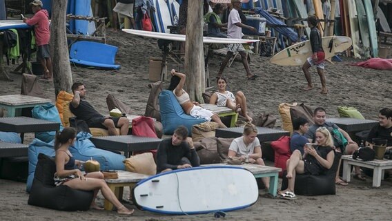 Viele Touristen entspannen sich an einer Bar am Strand. © picture alliance Foto: Johannes P. Christo