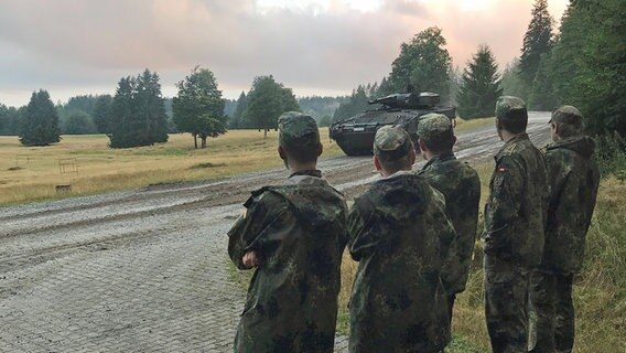 Fünf Bundeswehrsoldaten sehen zu einem Panzer in einem Naturgebiet. © BR24 Foto: Kilian Neuwert