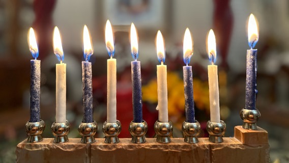 Die Kerzen auf einem Menora-Leuchter brennen. © picture alliance Foto: Amy Katz
