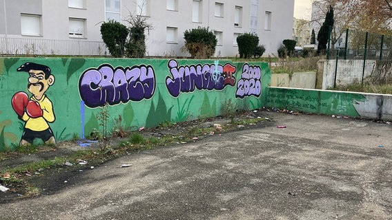 Leerer verwahrloster Spielplatz mit Graffiti in La Monnaie. © ARD Foto: Julia Borutta