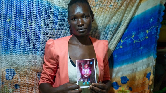 Modestar Lumbasi aus dem Mukuru-Slum in Nairobi mit einem Bild ihres Sohnes. © ARD Foto: Srdjan Govedarica
