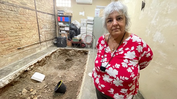 Merced Guimaraes vor einer Ausgrabungsstelle in ihrem Haus. © ARD Foto: Anne Herrberg