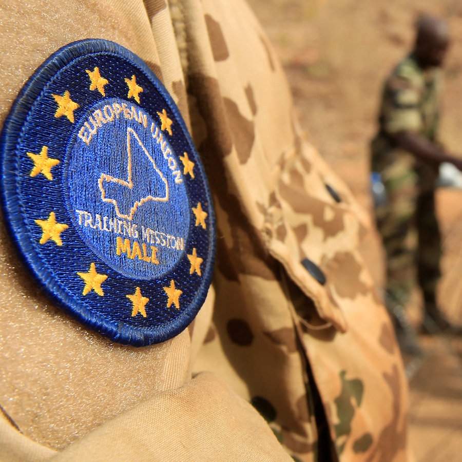 Abzeichen der EU-Ausbildungsmission am Oberarm eines Bundeswehrsoldaten. Im Hintergrund malische Soldaten. © Bundeswehr Foto: Andrea Bienert