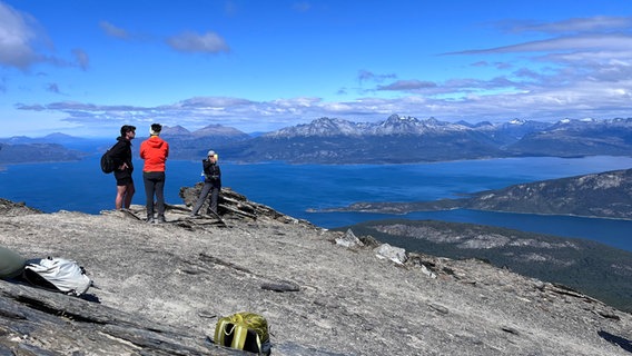 Zwei Menschen in Argentinien laufen auf einem Berg, dahinter ist der blaue Himmel zu erkennen © NDR Foto: Max-Marian Unger