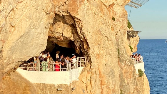 Wanderende Touristen in einer der Höhlen an den Steilküsten von Menorca © NDR Foto: Carsten Vick