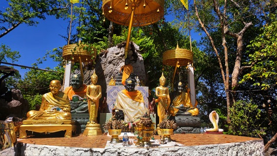 Ein Tempel in Thailand mit goldenen Figuren von Buddha und anderen Objekten auf einer Insel bei Khanom © NDR Foto: Isa Hoffinger