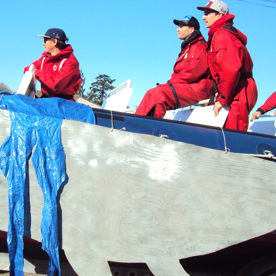 Ein Team in roten Anzügen auf einem Schnellboot, das Wale in Vancouver (Pacific Rim) beobachten will © NDR Foto: Guido Meyer