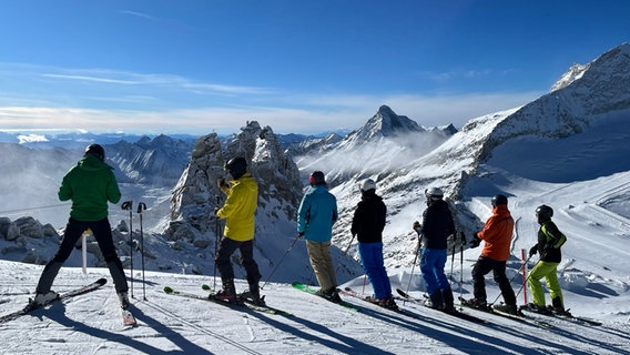 Österreich, Hintertux: Wintersportler stehen auf dem Hintertuxer Gletscher und schauen Richtung Schlegeisspeicher. © dpa Foto: Jan Woitas