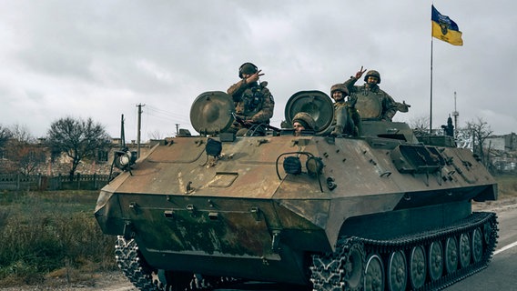 Ukrainische Soldaten fahren in Cherson mit einem erbeuteten russischen Schützenpanzer. © Libkos/AP/dpa 