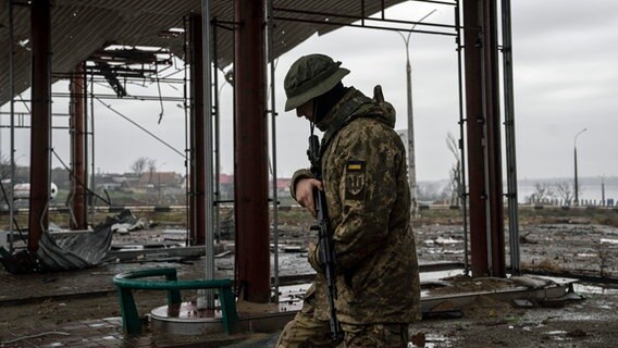 Ein ukrainischer Soldat patrouilliert in der Nähe der Antoniwkabrücke in Cherson. © Evgeniy Maloletka/AP/dpa 