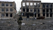 Ein ukrainischer Soldat vor zerstörten Häusern in Awdijiwka in der Region Donezk (Archiv) © LIBKOS/AP/dpa Foto: LIBKOS
