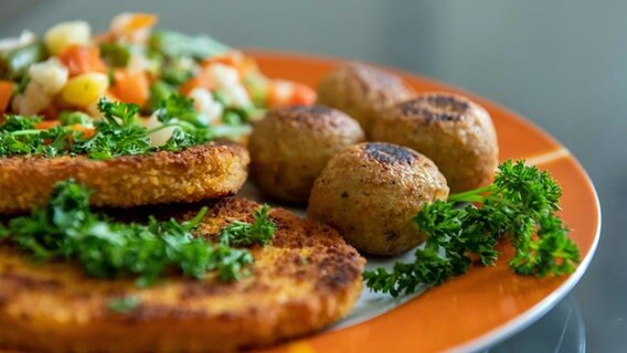 Falafel, vegane Schnitzel und Gemüse liegen auf einem Teller in einer Küche. © picture alliance/dpa | Silas Stein 