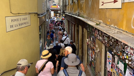 Besucher drängen sich in der "Calle de la Madoneta", eine der engen Gassen. © Christoph Sator/dpa 