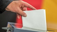 Ein Wähler wirft seinen Stimmzettel zur Bundestagswahl in die Wahlurne. (Archiv-Foto) © Michael Kappeler/dp 