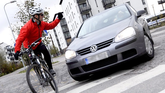 Streit zwischen einem Rad- und einem Autofahrer an einem Zebrastreifen. © picture-alliance Foto: Vesa Moilanen
