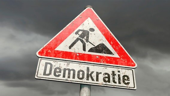 Symbolbild zum Thema Demokratie in der Krise: Ein Bauarbeiten-Schild, darunter der Schriftzug "Demokratie". © picture alliance / Zoonar | DesignIt 
