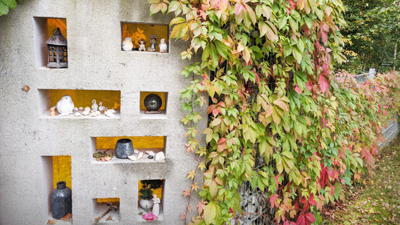 Steinwand geschmückt mit Vasen, Kerzen und kleinen Figuren im Garten des Rostocker Hospiz © NDR Foto: Katja Bülow
