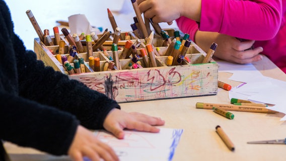 Kinderhände greifen in eine Holzbox mit Stiften. (Kita "Naturtalent" Ludwigslust, MV) © Picture Alliance Foto: Jens Büttner/ZB/dpa