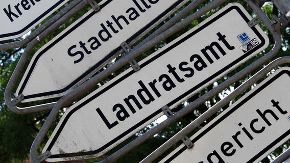 Straßenschilder die beschriftet sind mit Landratsamt, Stadthalle, Kreisverwaltung, © dpa Foto: Jens Büttner