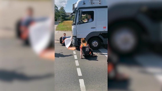 Ein auf der Straße sitzender Demonstrant wird von einem LKW angefahren. © NDR Foto: screenshot