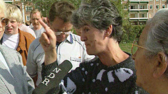 Eine Frau spricht in ein Mikrofon, Rostock Lichtenhagen 1992  