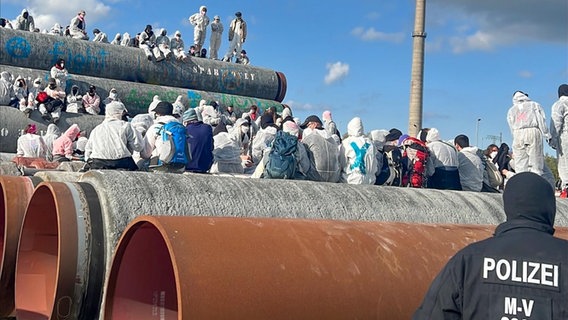 Demonstranten klettern im Hafen von Mukran auf Rohre des geplanten LNG-Terminals. © ndr Foto: Marek Walde