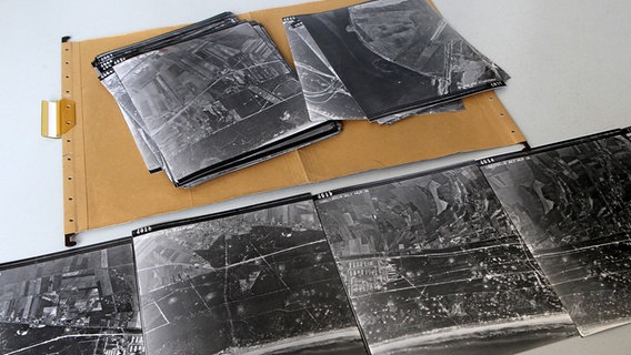 Luftbildaufnahmen von Peenemünde vom Juli 1944 liegegn auf einem Tisch. © picture-alliance / ZB Foto: Bernd Wüstneck