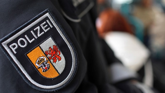 Das Wappen der Polizei Mecklenburg-Vorpommern an der Uniform eines Polizeibeamten. © dpa/picture alliance Foto: Jens Büttner