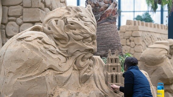 Binz/Prora: Eine Frau arbeitet an einer Sandskulptur der Sandskulpturen-Schau "Zurück ins Mittelalter" © Stefan Sauer/dpa Foto: Stefan Sauer/dpa