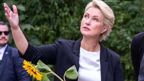 Manuela Schwesig (SPD), Ministerpräsidentin von Mecklenburg-Vorpommern, beim Lichtenhagen-Gedenken mit einer Sonnenblume. © dpa Foto: Jens Büttner