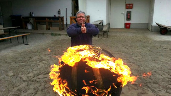 Fred Bräutigam vor einer brennenden Kugel. © NDR Foto: Fred Bräutigam