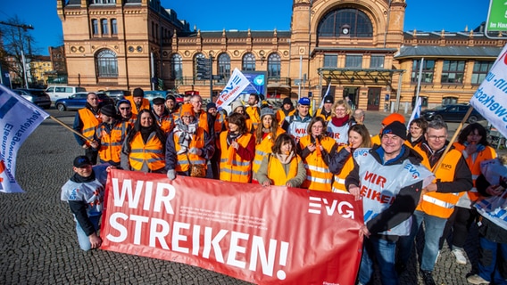 Schwerin: Mitglieder der Gewerkschaft EVG beteiligen sich am Warnstreik und demonstrieren vor dem Hauptbahnhof für mehr Gehalt in der laufenden Tarifrunde. © dpa Foto: Jens Büttner