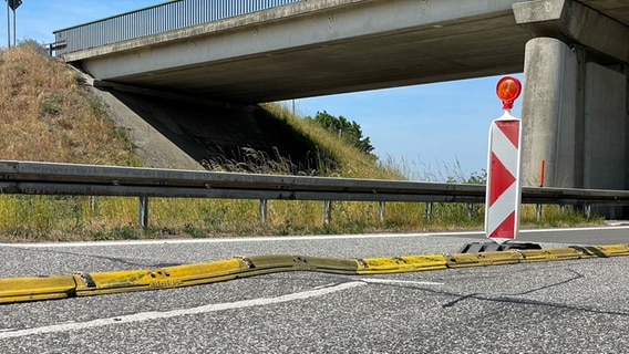 Hitzebedingte Blow-Ups haben Schäden auf der Autobahn 14 hinterlassen. Eine Bodenwellle ist durch Warnbarken gekennzeichnet. © NDR MV Foto: Christoph Kümmmritz/ NDR MV