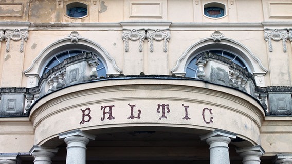 Rund um den Säulengang im Erdgeschoss steht der Schriftzug "Baltic", darüber ist ein Teil der Balkonbrüstung rausgebrochen. © NDR.de Foto: Daniel Sprenger