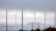 Parchim: Tief hängende Wolken ziehen über Anlagen in einem Windpark. © Jens Büttner/dpa +++ dpa-Bildfunk +++ Foto: Jens Büttner/dpa +++ dpa-Bildfunk +++