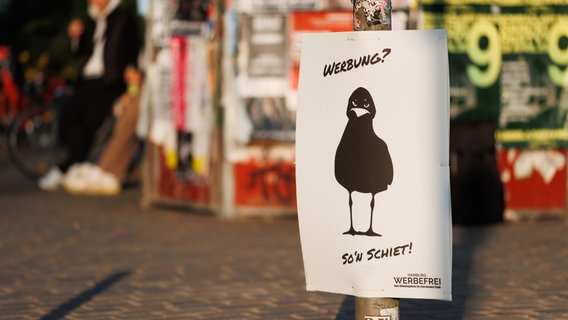 Werbung für das Volksbegehren "Hamburg Werbefrei" vor anderen Werbeplakaten. © NDR Foto: Alexander Mühlhausen