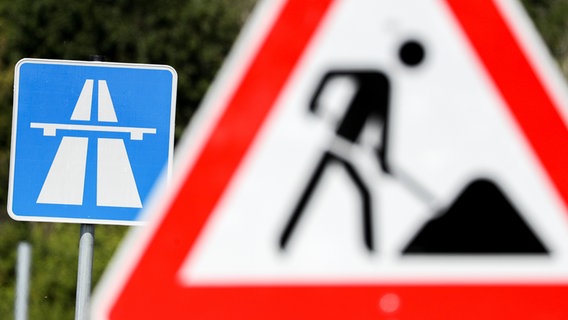 Vor einem Autobahnschild ist ein Baustellenschild zu sehen. © picture alliance/zb/dpa Foto: Jan Woitas