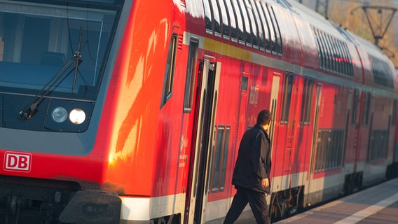 Ein Mann steigt aus einer Regionalbahn. © picture alliance Foto: Philipp Schulze