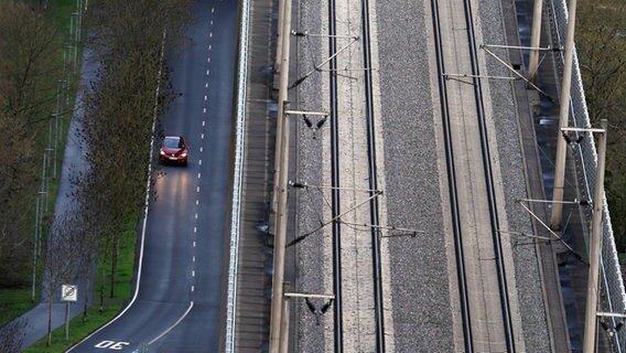 Ein Auto fährt auf einer Straße neben leeren Bahnschienen. © dpa Bildfunk Foto: Karl-Josef Hildenbrand